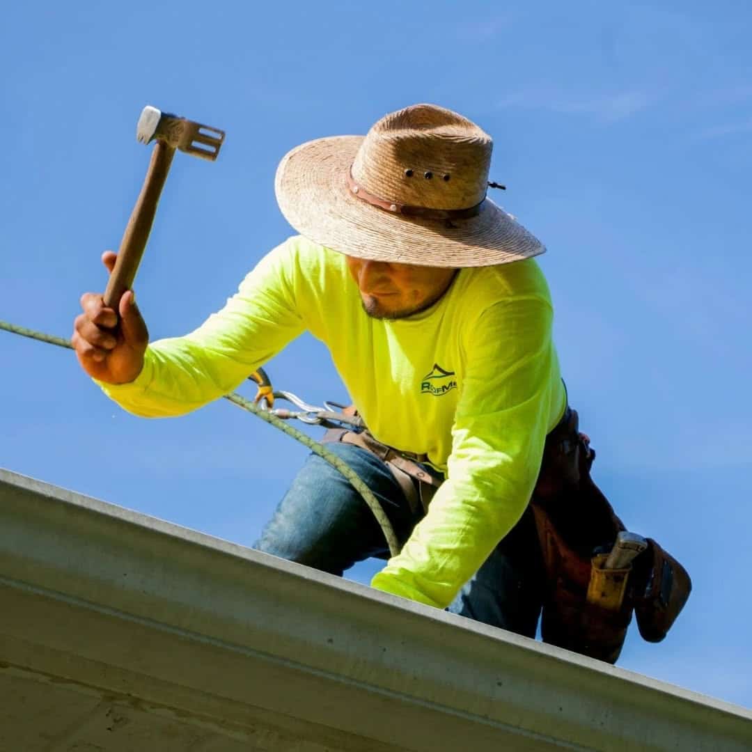 Roofer works on roof storm damage.